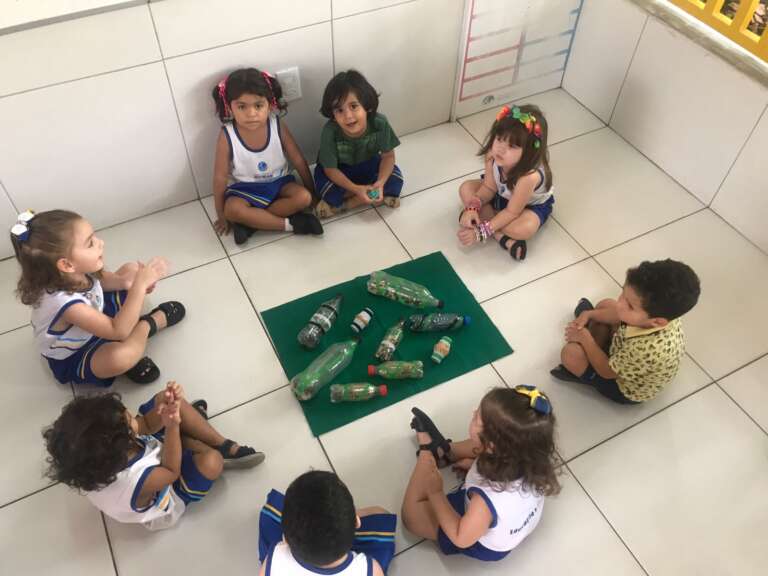 crianças se socializando com atividade na sala de aula
