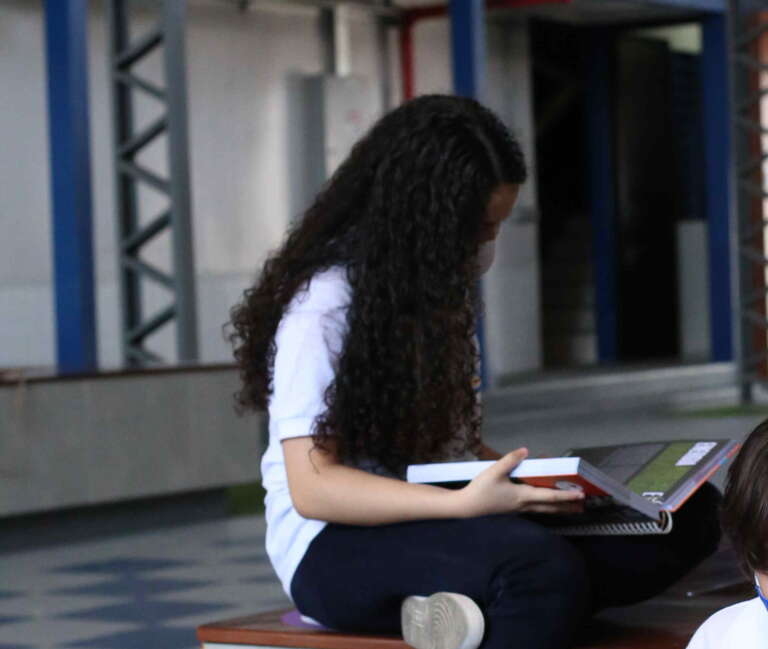 aluna estudando livro no pátio do enem