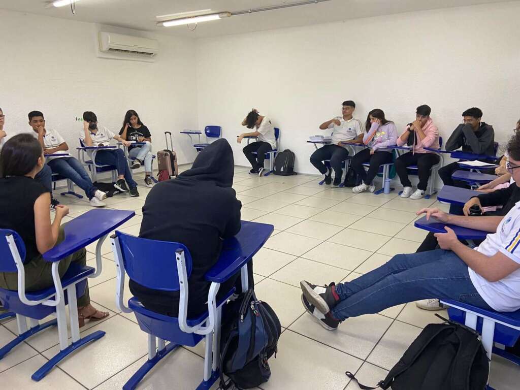 alunos em sala de aula com cadeiras fazendo um circulo