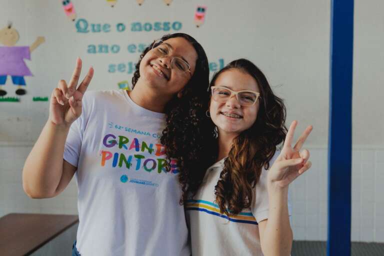 dusa alunas do curso pre-vestivular pousando para a foto fazendo dois com a mão