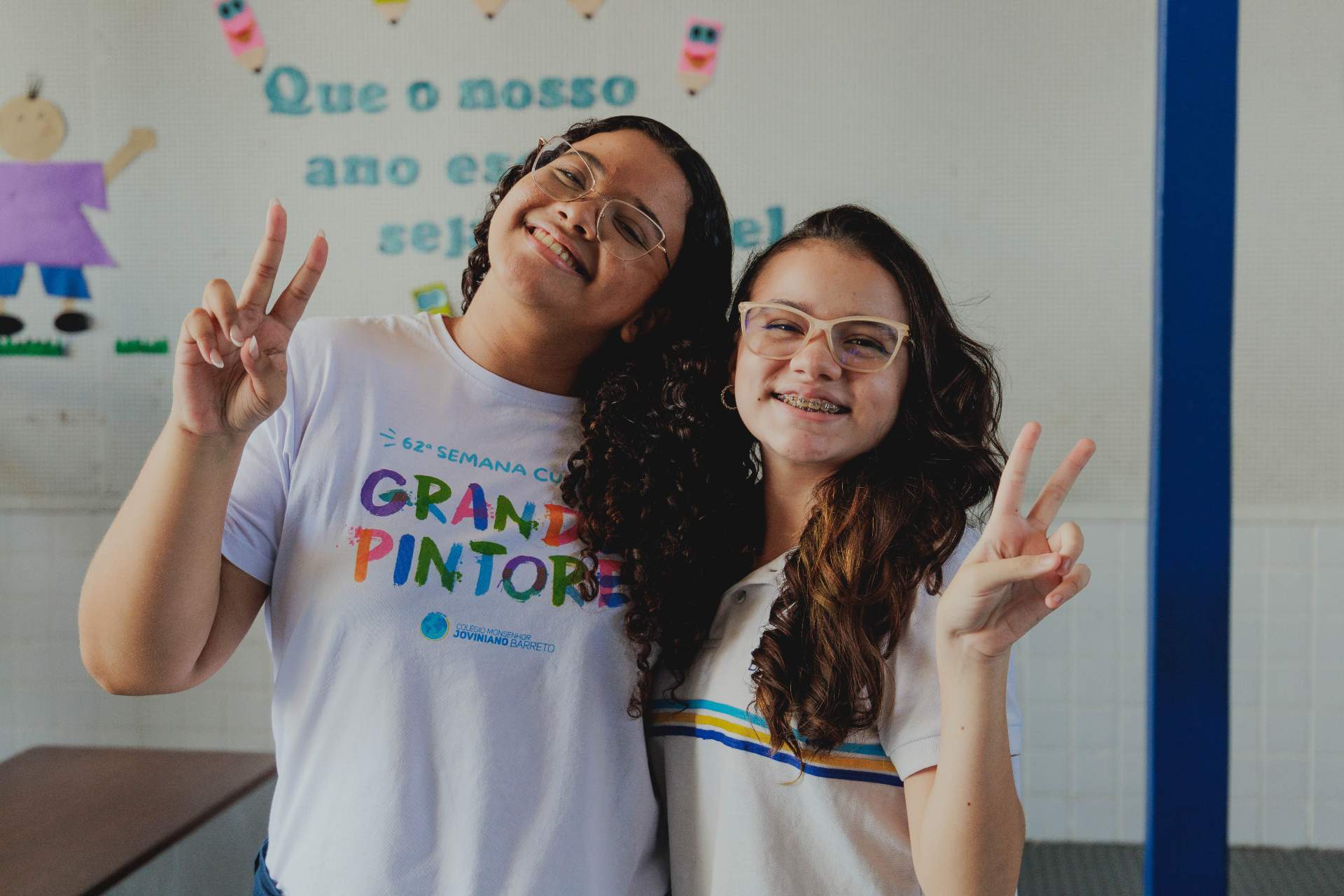 dusa alunas do curso pre-vestivular pousando para a foto fazendo dois com a mão