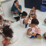 sala de aula com alunos lendo livros para crianças