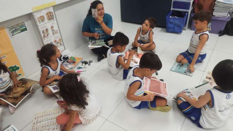 sala de aula com alunos lendo livros para crianças